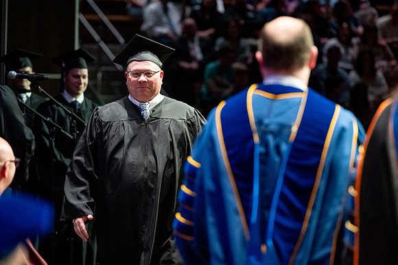 Graduates walk across the stage.
