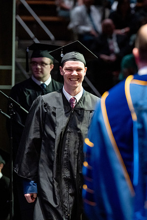 Graduates walk across the stage.