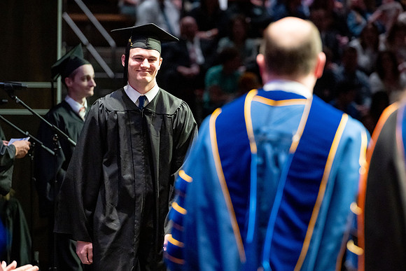 Graduates walk across the stage.