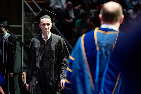 Graduates walk across the stage.