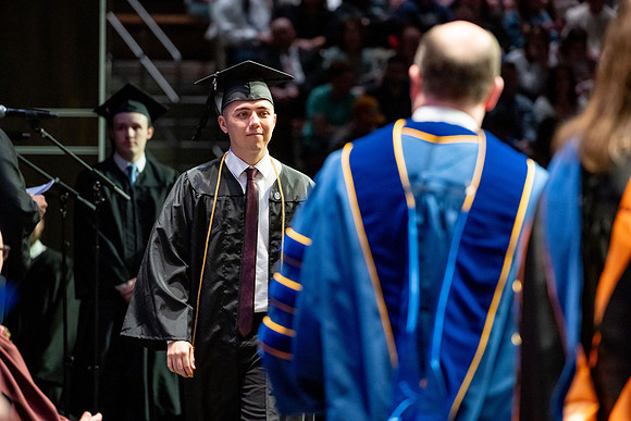 Graduates walk across the stage.