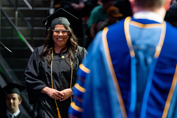 Graduates walk across the stage.