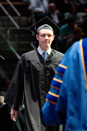 Graduates walk across the stage.