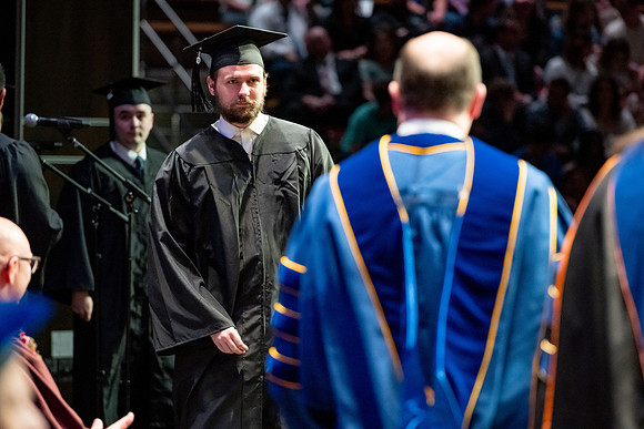 Graduates walk across the stage.