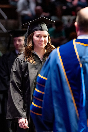 Graduates walk across the stage.