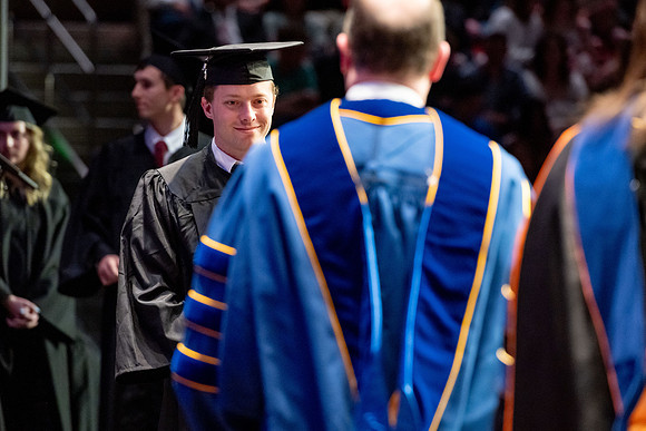 Graduates walk across the stage.