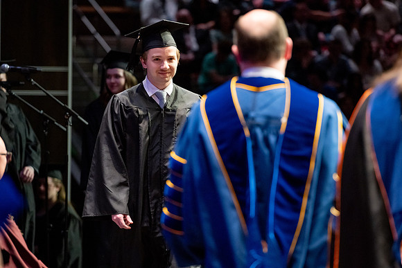 Graduates walk across the stage.