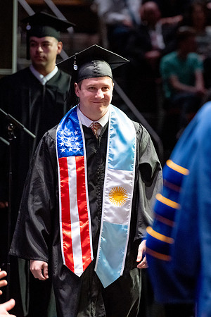 Graduates walk across the stage.