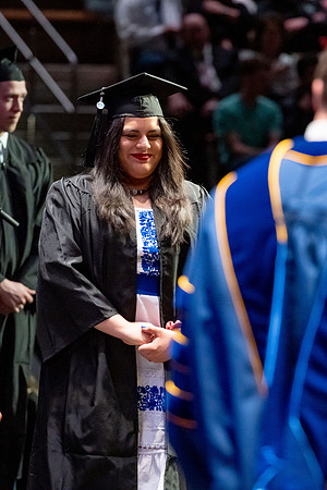 Graduates walk across the stage.