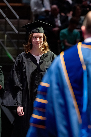Graduates walk across the stage.