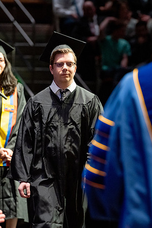 Graduates walk across the stage.