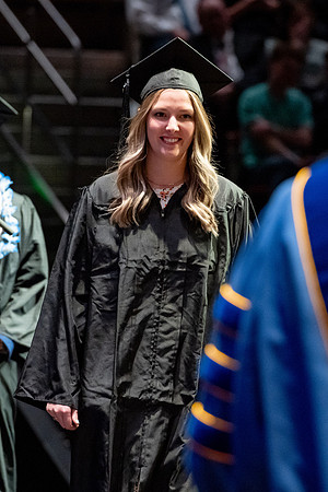 Graduates walk across the stage.