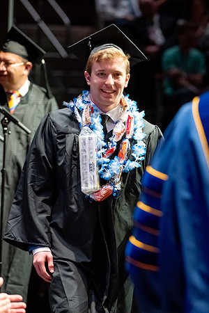 Graduates walk across the stage.