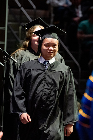 Graduates walk across the stage.
