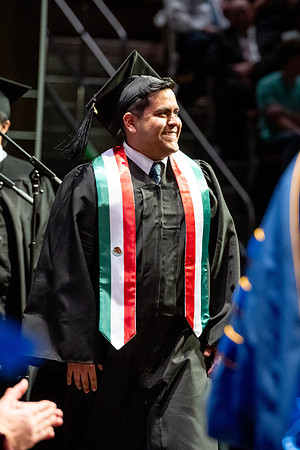 Graduates walk across the stage.