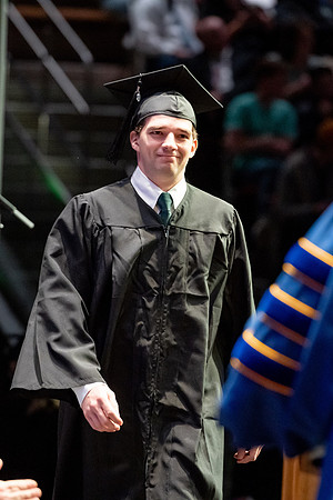 Graduates walk across the stage.