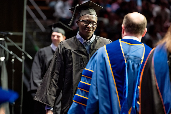 Graduates walk across the stage.
