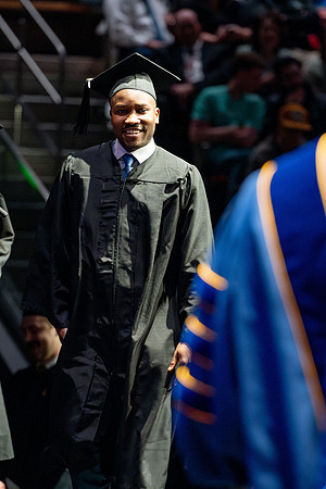 Graduates walk across the stage.
