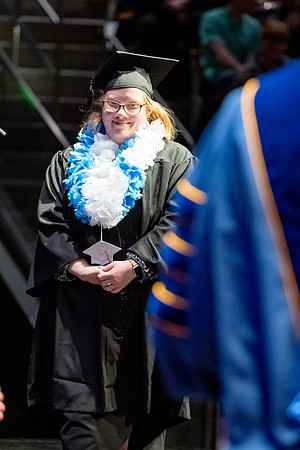 Graduates walk across the stage.