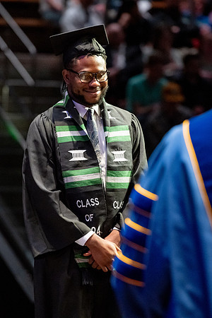Graduates walk across the stage.
