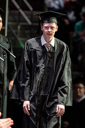 Graduates walk across the stage.