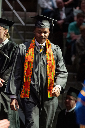 Graduates walk across the stage.