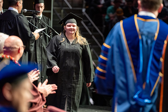 Graduates walk across the stage.