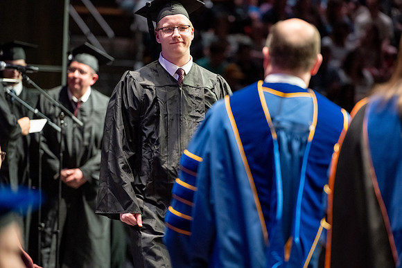 Graduates walk across the stage.