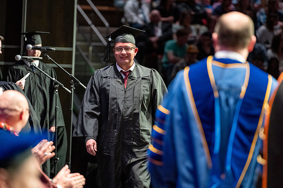 Graduates walk across the stage.