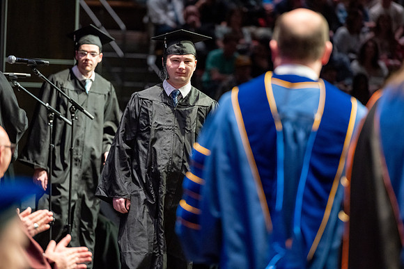 Graduates walk across the stage.