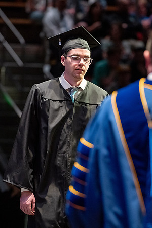 Graduates walk across the stage.