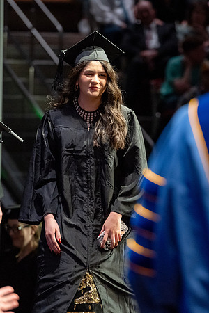 Graduates walk across the stage.