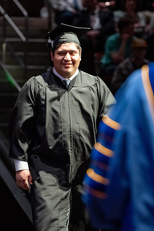 Graduates walk across the stage.