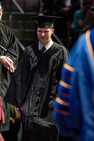 Graduates walk across the stage.