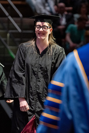 Graduates walk across the stage.