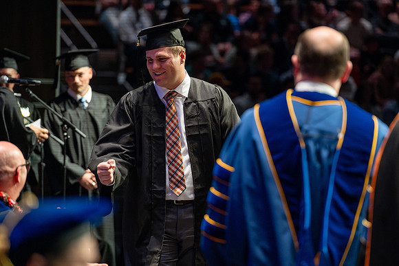 Graduates walk across the stage.