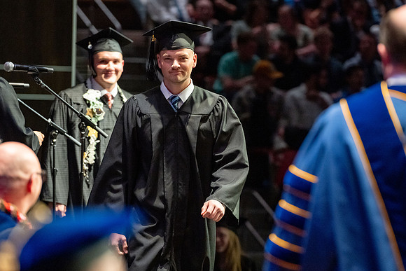 Graduates walk across the stage.