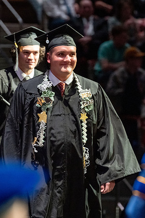 Graduates walk across the stage.