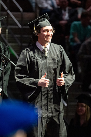 Graduates walk across the stage.