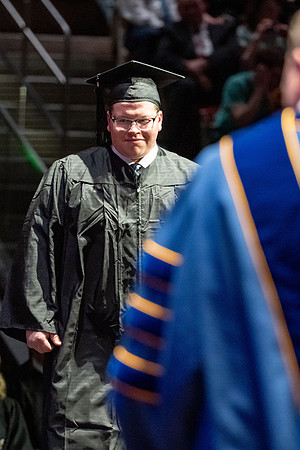 Graduates walk across the stage.