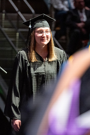 Graduates walk across the stage.