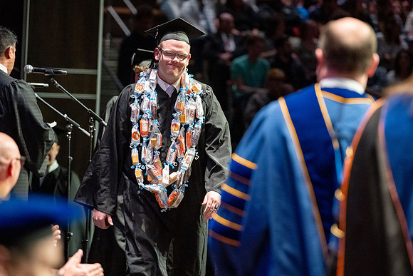 Graduates walk across the stage.
