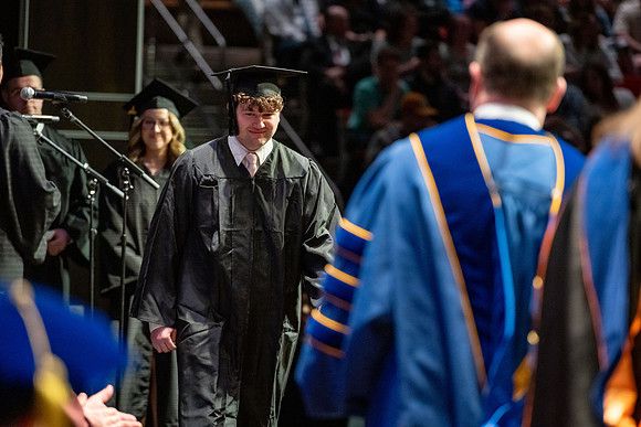 Graduates walk across the stage.