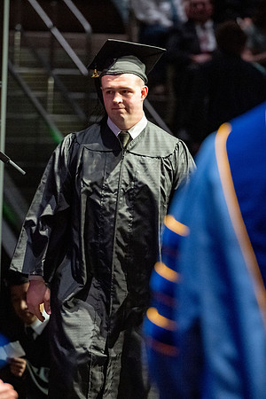 Graduates walk across the stage.
