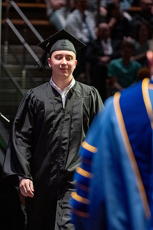 Graduates walk across the stage.