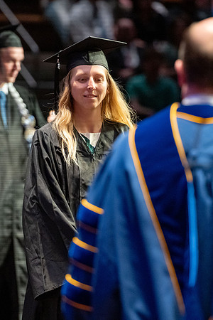 Graduates walk across the stage.