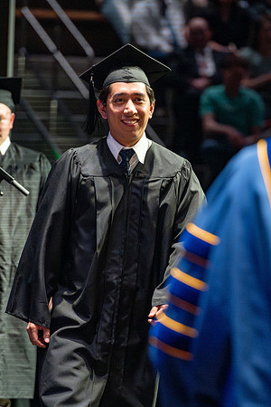 Graduates walk across the stage.