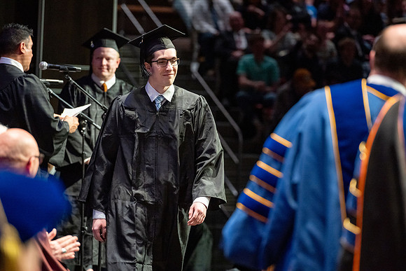 Graduates walk across the stage.