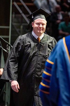 Graduates walk across the stage.