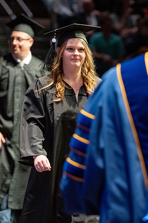 Graduates walk across the stage.